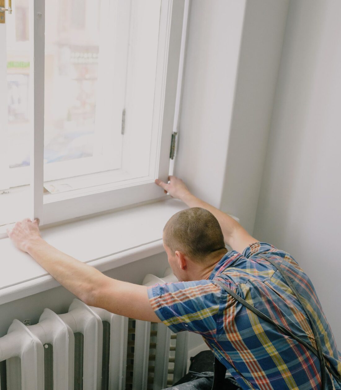 Tradesperson checking a window during property maintenance